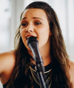 Dayna singing into a microphone
