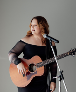 Rhiannon Kate singing and playing acoustic guitar