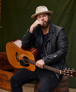 Timothy James Bowen, Sydney singer, seated with acoustic guitar
