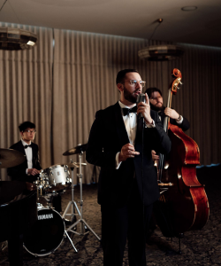 The Uprights jazz band in tuxedos with vocalist, drums and double bass