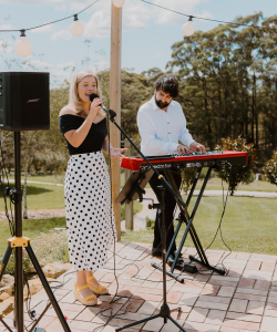 Zoe Vrachnas singing with a keyboard player at an outdoor event