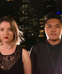 Bronte and Dom Duo against a city skyline at night