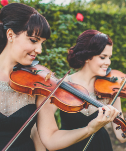 Diamond Strings Ensemble violinists playing in a garden