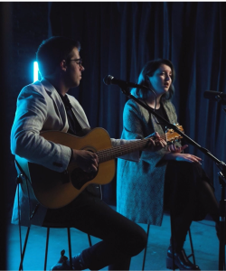 Indigo Hour acoustic duo performing under blue lighting