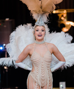1920s Showgirl in a white feathered costume and headdress at a Sydney event