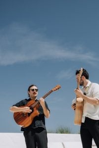Yeah Nah Yeah Duo playing acoustic guitars and one musician wearing sunglasses