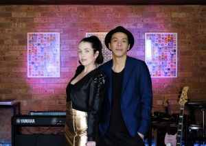 Kristen Fletcher duo posing in front of a brick wall with keyboard