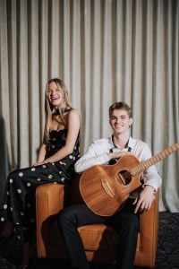 Harlow acoustic duo seated with acoustic guitar